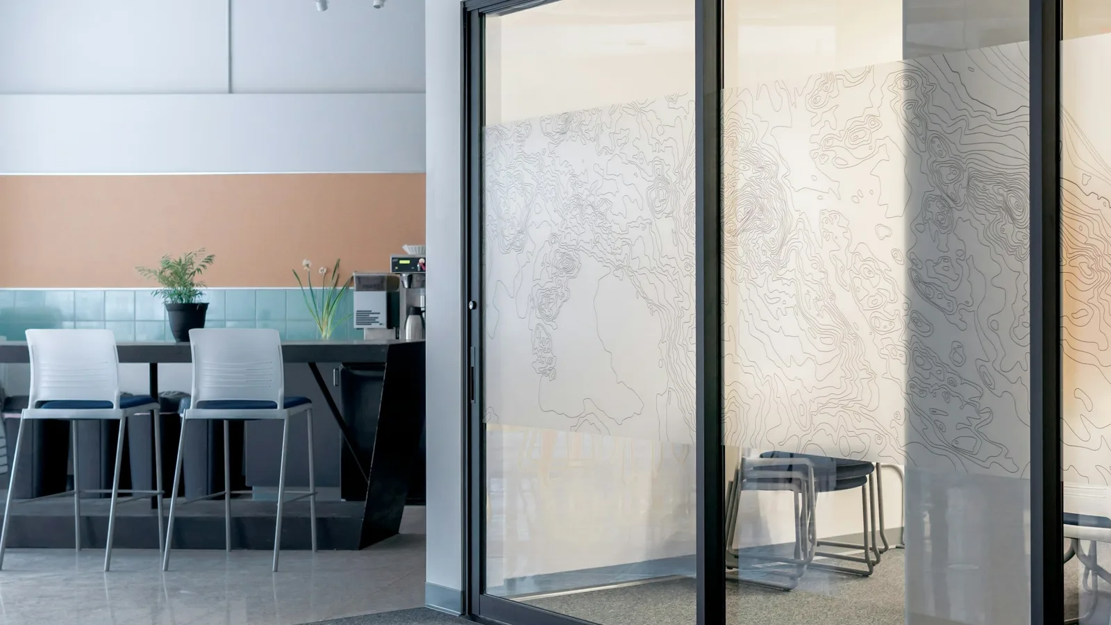 Black-framed sliding glass panels with recessed handles and a floor track