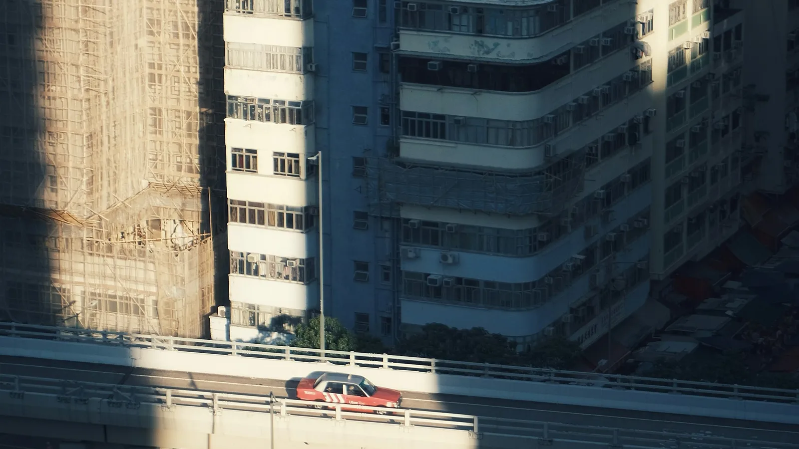 Urban traffic viewed from a building above an elevated roadway