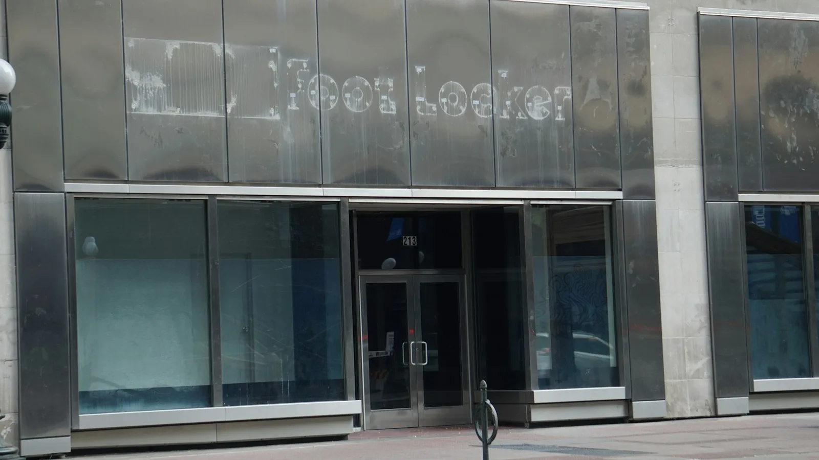 Commercial facade with tall glass panels and a recessed glazed entrance